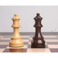 Handcarved boxwood and dark rosewood queen chess pieces standing together on a glossy checkered chessboard.