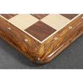 Detailed macro shot of the rounded corner and natural wood grain of the Golden Rosewood chess board border.