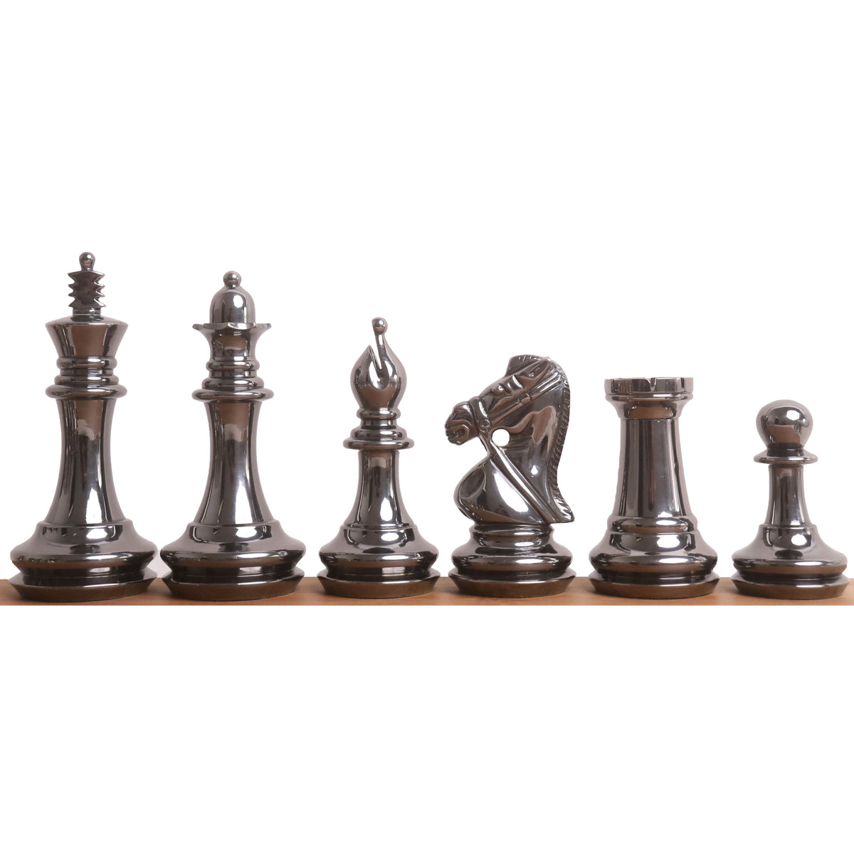Lineup of grey luxury brass metal chess pieces showing sleek metallic contours from king to pawn on a white background.