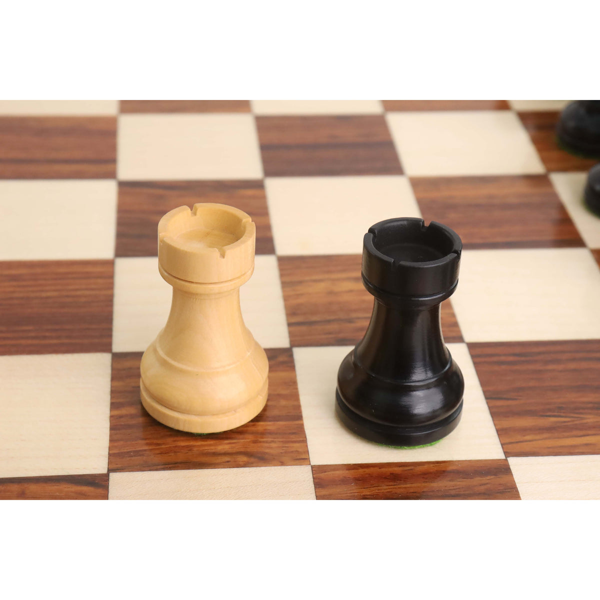 Pair of tournament Staunton rooks in ebonised and natural boxwood on a checkered board.
