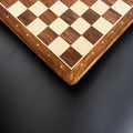 Angled overhead perspective of the algebraic notations bordering the wooden chess board.