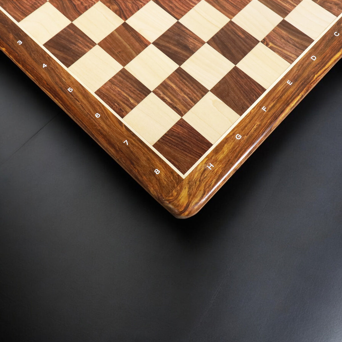 Angled overhead perspective of the algebraic notations bordering the wooden chess board.