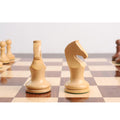 Two minimalist boxwood knight chess pieces showing distinct curved geometric profiles on a gloss chess board.