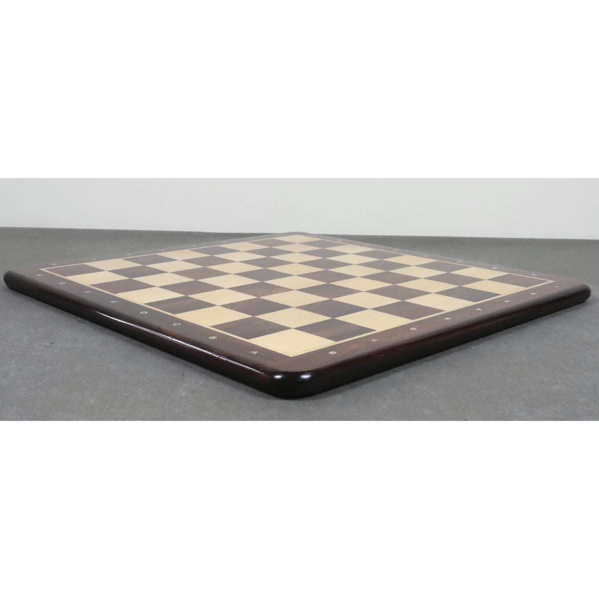 Perspective view of the thin, flat profile of the 21 inch Rosewood and Maple tournament chess board.