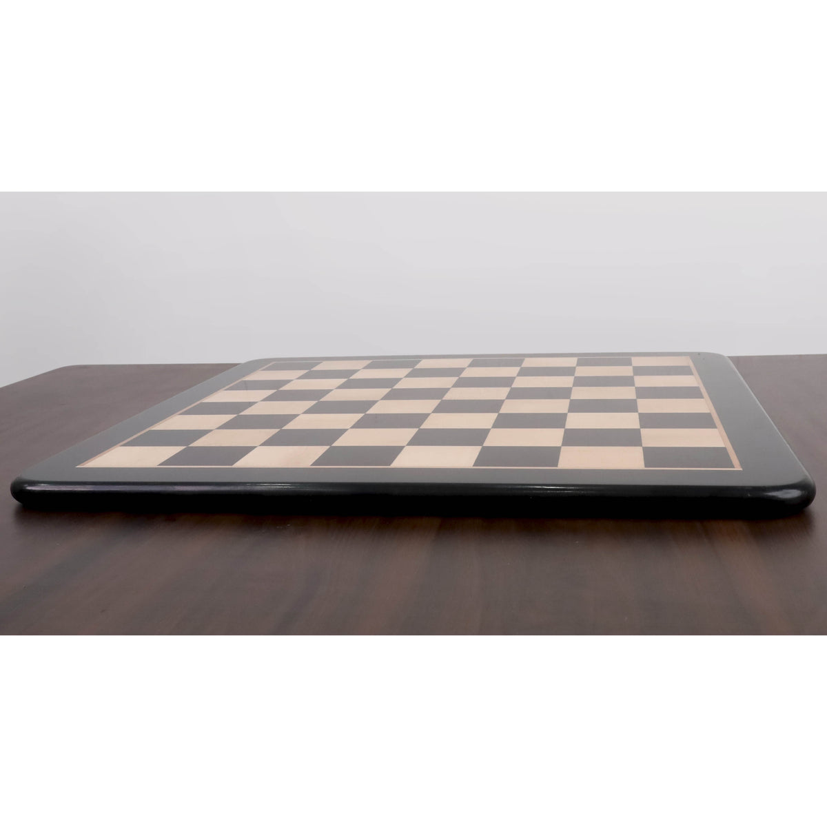 Low angle side view highlighting the sleek profile and solid wood construction of the 23 inch chess board.