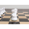 Close-up of a hand-carved white Pro Staunton knight chess piece on a polished ebony chess board.