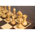 Grouped natural boxwood pieces of the 3.8" Candidates Series Minimalist chess set resting on a glossy chessboard.