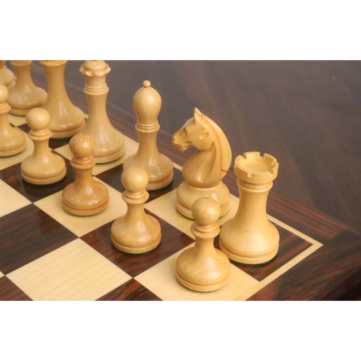 Grouped natural boxwood pieces of the 3.8" Candidates Series Minimalist chess set resting on a glossy chessboard.