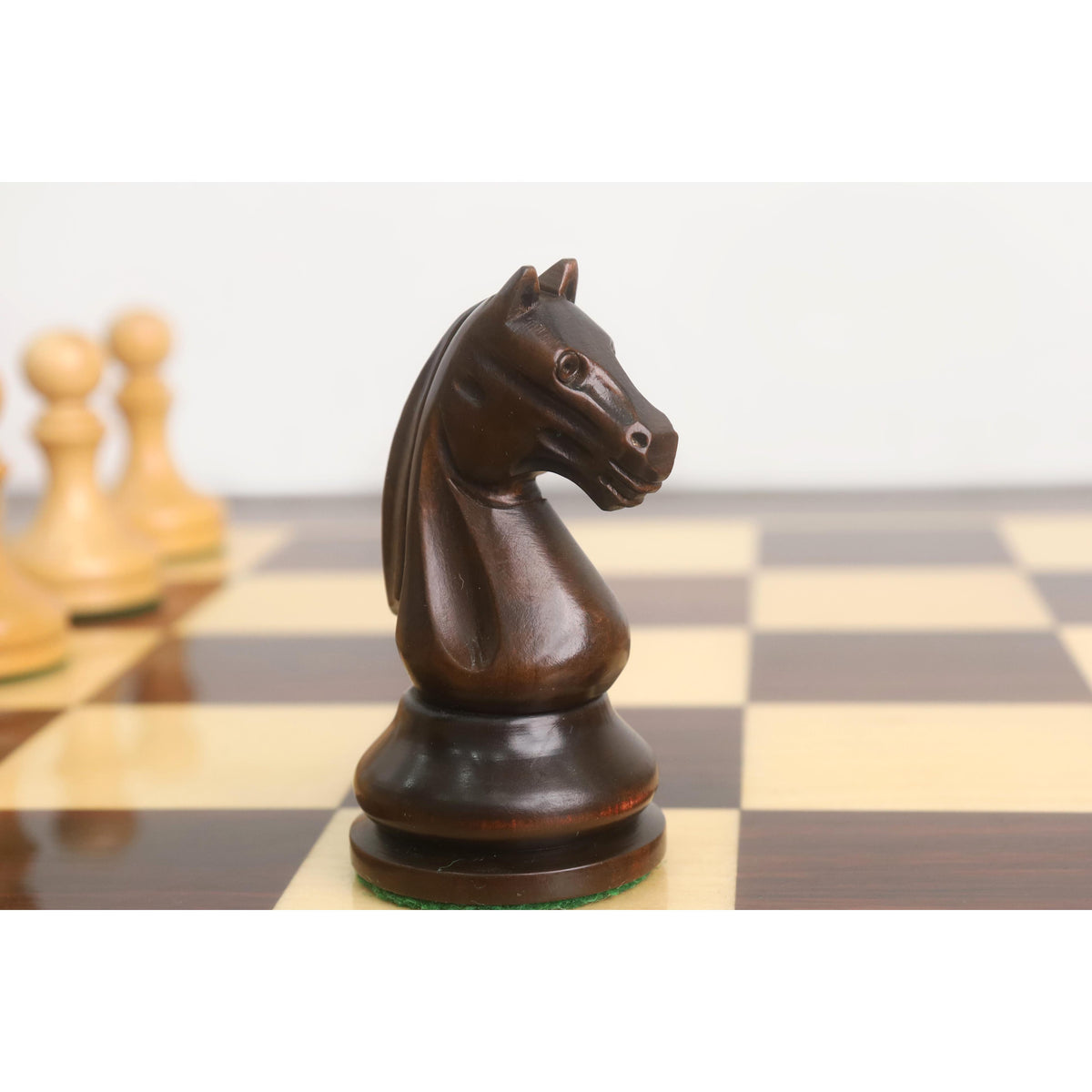 Close-up of the mahogany stained boxwood Knight from the 3.8" Candidates Series Minimalist chess set on a board.