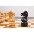 Natural boxwood and ebonised Laughing Knight Staunton knights facing each other on a wooden chess board.