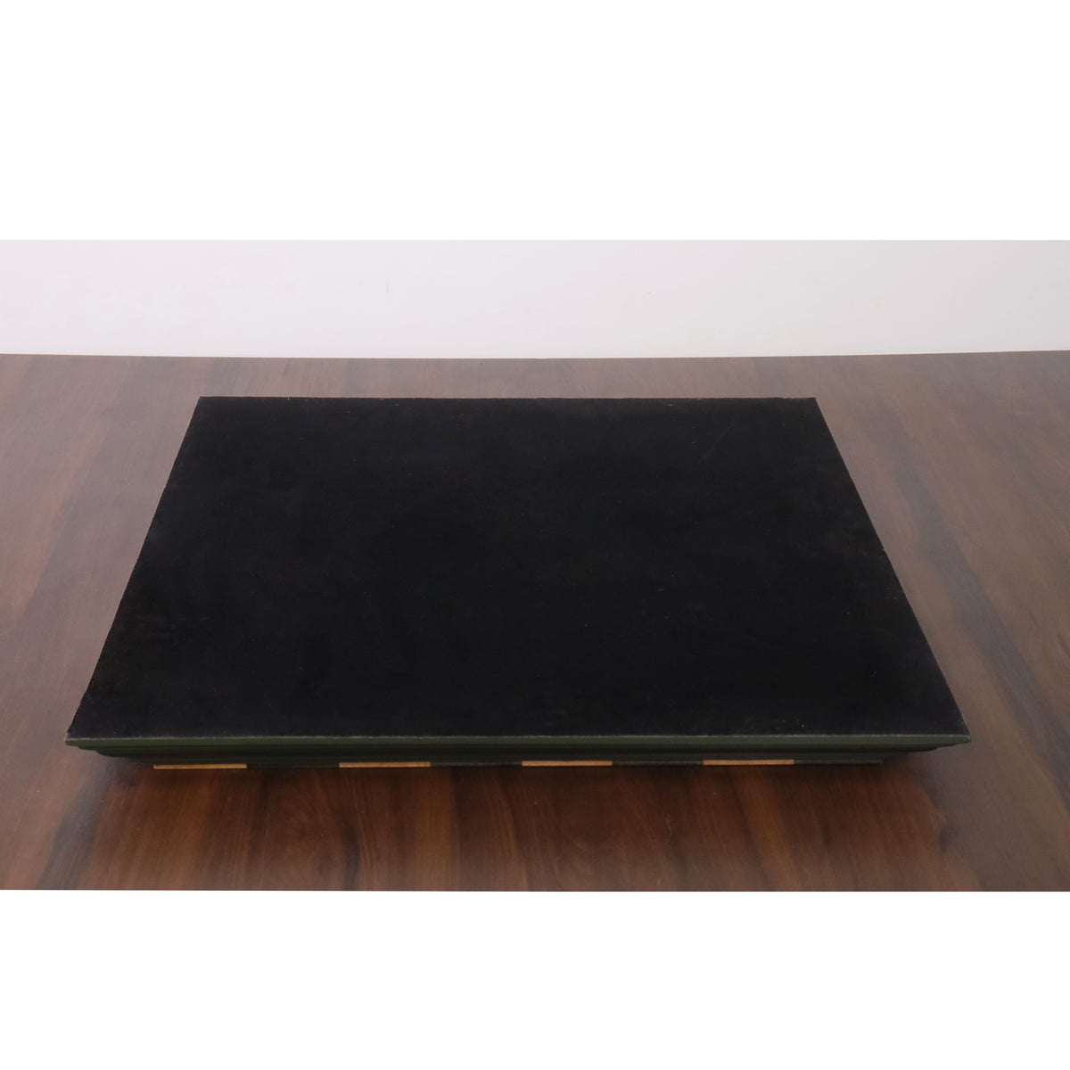 Underside of the green and maple chess board featuring a protective black felt lining.