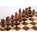 Set of hand-carved dark rosewood staunton chess pieces on a wooden board.