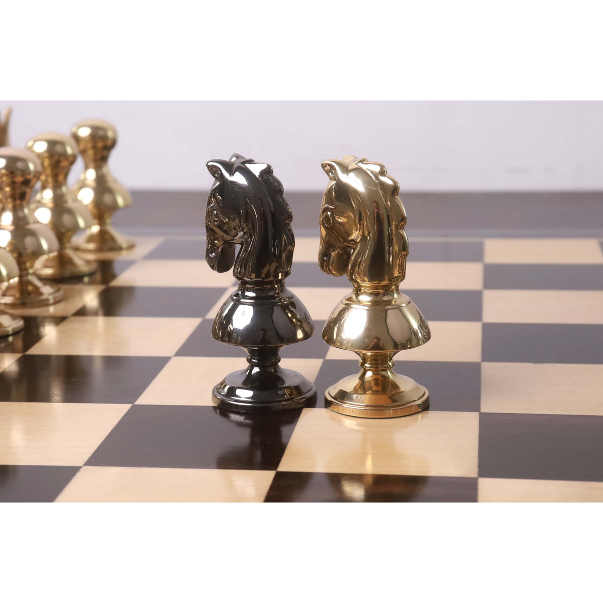 Detailed back angle of gold and grey Victorian brass metal chess knights.