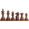 Weighted golden rosewood Staunton chess pieces showing grain and hand-carved details.