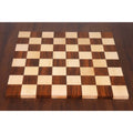 Top-down view of the 8x8 grid on a borderless hardwood end grain chess board.