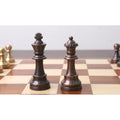 Close-up of a copper metal Pro Staunton king and queen standing together on a chessboard.