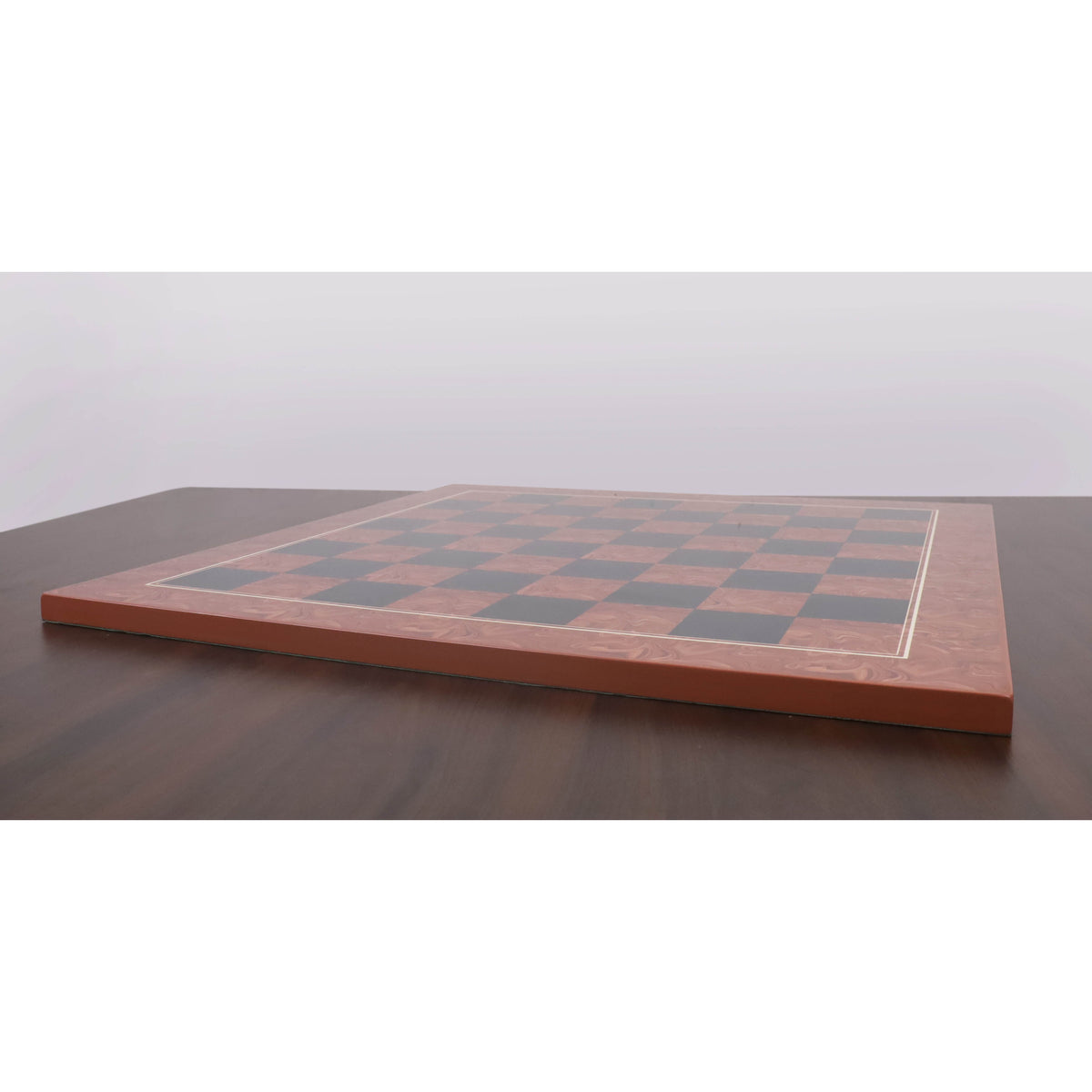 Side profile view of the printed chess board on a dark wooden table, showing its thickness and flat construction.