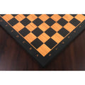 Wide corner shot of the 21" wooden chess board on a table, showcasing the contrast between the light boxwood squares and the dark ebony border.