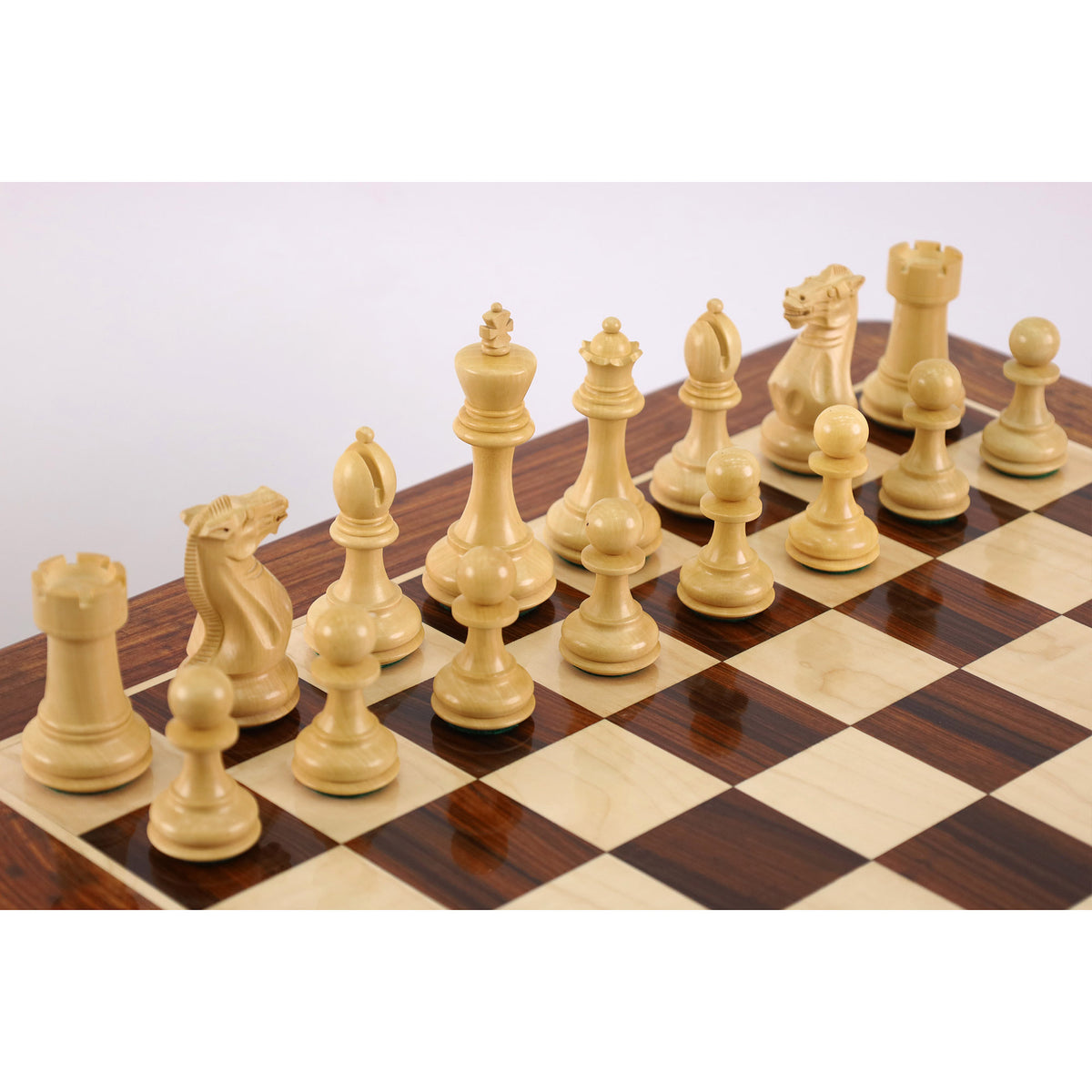 Hand-carved light boxwood staunton chess pieces on a tournament board.