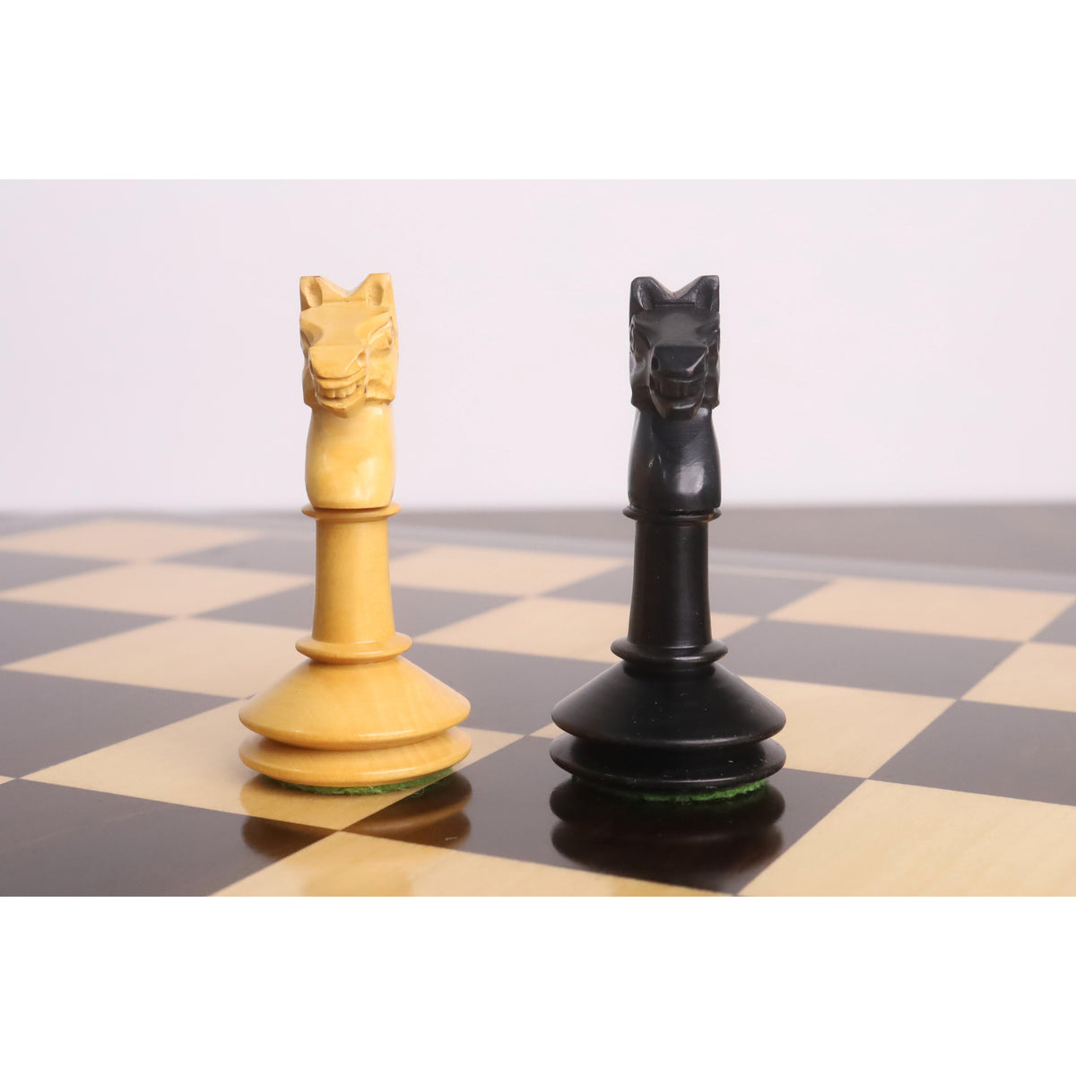 Front-facing view of the meticulously carved boxwood and ebonised knights from the Monolith miniature chess set.