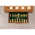 Green felt-lined storage drawer of a chess table with organized boxwood chess pieces.