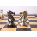 Detailed view of metallic gold and grey chess knights.