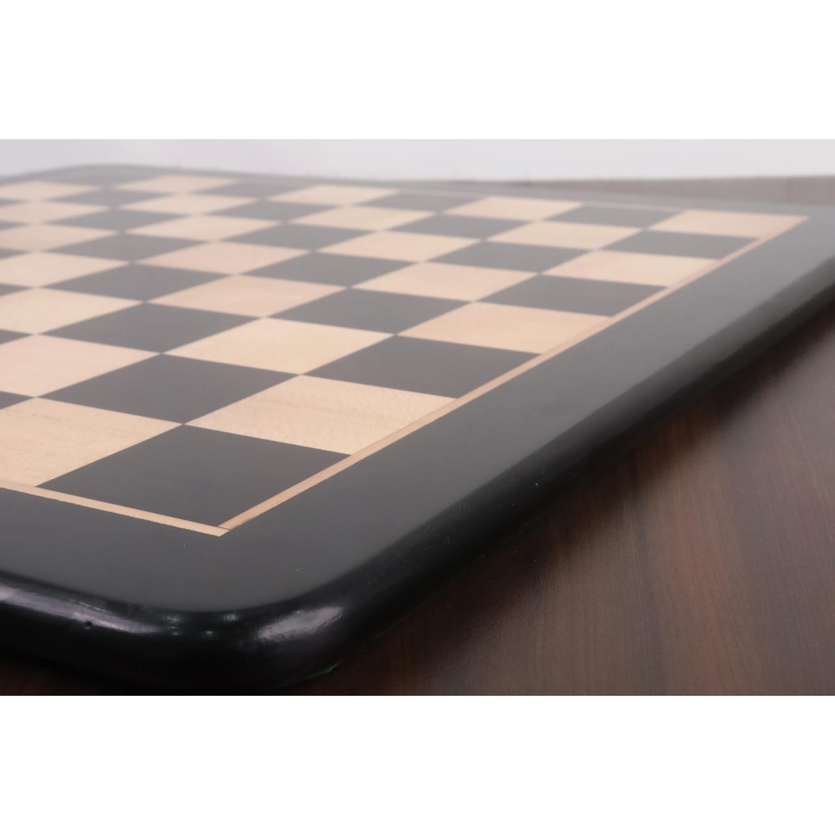 Close-up of the smooth black border and inlaid maple surface of the high-quality tournament chess board.