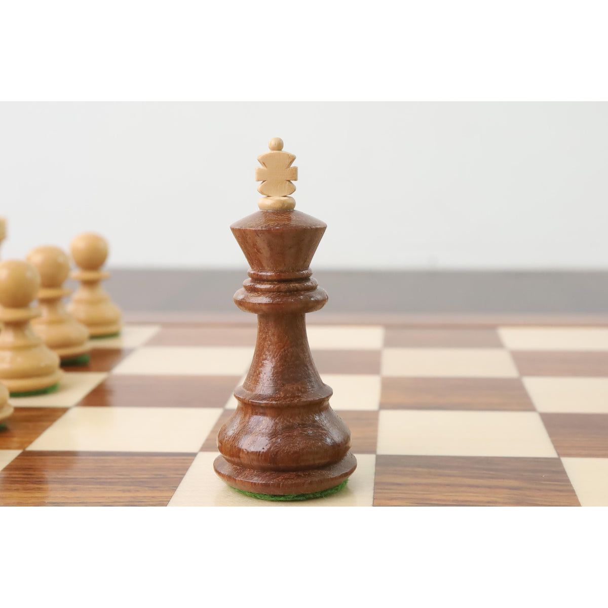 Weighted Russian Zagreb King chess piece in rich golden rosewood on a board.