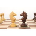 White boxwood and dark golden rosewood knights facing each other on a wooden chess board.