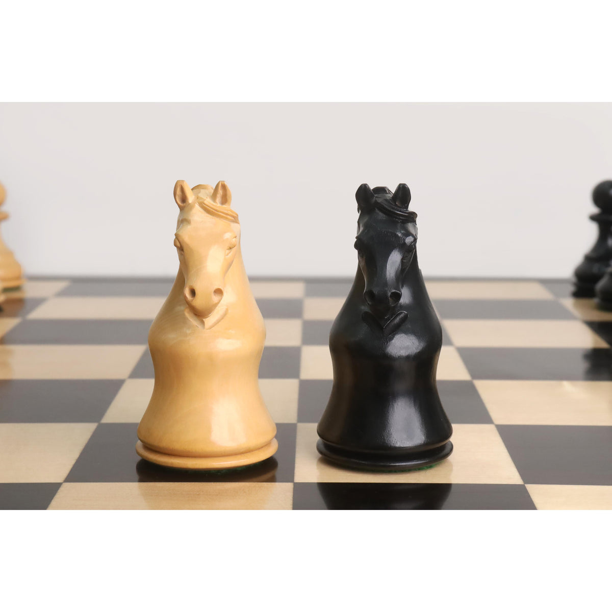 Front view of intricately carved light and dark Piatigorsky Cup chess knights.