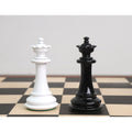 Black and white texture painted Staunton Queen chess pieces standing side-by-side on a wooden chessboard.