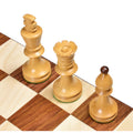 Diagonal high-angle view of Romanian Hungarian boxwood king, queen, and bishop pieces on a chessboard.