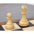 A natural boxwood pawn and bishop from the 4-inch Leningrad Staunton chess set on a wooden board.