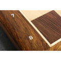 Close-up of the engraved white algebraic numbers 7 and 8 on the solid Rosewood border of the chessboard.