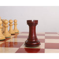 Bud Rosewood rook of a 4.6" Bath Luxury Staunton chess set standing on a wooden board.
