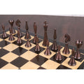 Antiqued copper chess pieces displayed on a wooden chess board.