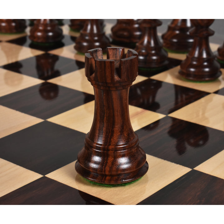 Handcrafted rosewood rook chess piece standing on a wooden chess board.