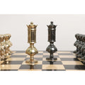 Detailed view of the opposing brass metal luxury chess set queen pieces standing on an ebony wood board.