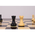 Black ebony and white boxwood luxury chess rooks facing each other on a chessboard.