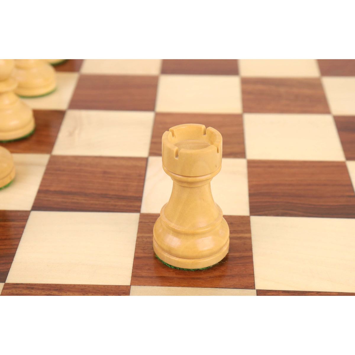Light boxwood rook from the 3.3 inch tournament Staunton chess set positioned on a chessboard.
