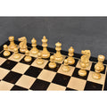 Natural boxwood white pieces of the 1972 Fischer Spassky chess set lined up on a black and white board.