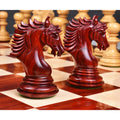 Detailed view of two premium bud rosewood knights on a glossy wooden chessboard.