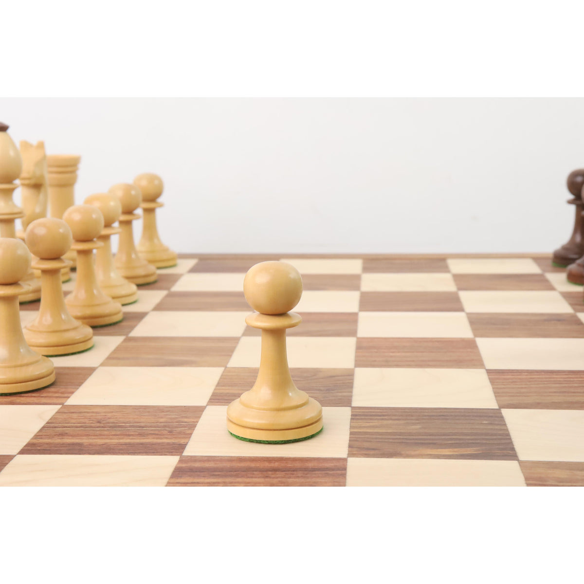 A single light boxwood pawn piece centered on a chessboard.