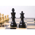 Black king and queen from the ebonised boxwood Tournament Staunton chess pieces set standing side by side.