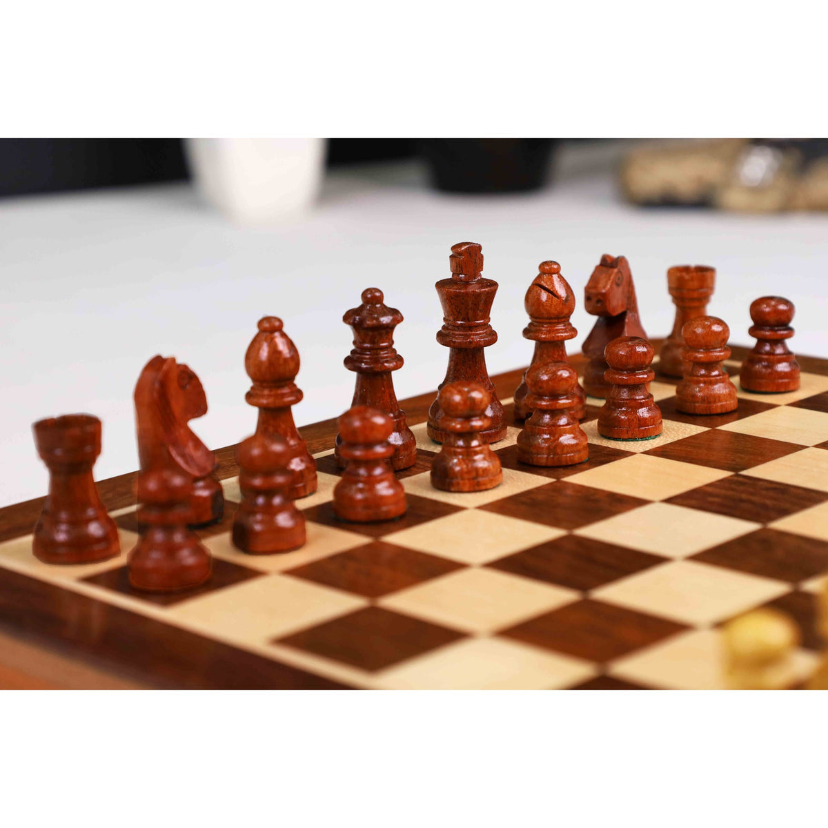 Dark wooden chess pieces arranged on a professional travel-sized magnetic board.
