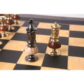 Close-up of the metallic grey King and gold Queen from the Victorian Fusion brass metal luxury chess set on a board.