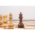 Boxwood and golden rosewood Staunton queen pieces on a wooden chess board.