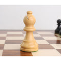 Natural boxwood bishop piece with a traditional miter cut on a wooden chess board.