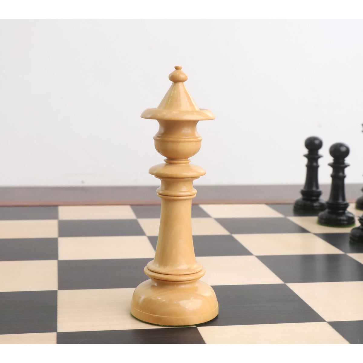 Elegant boxwood queen piece from the Edinburgh upright pre-Staunton chess set on a chessboard.