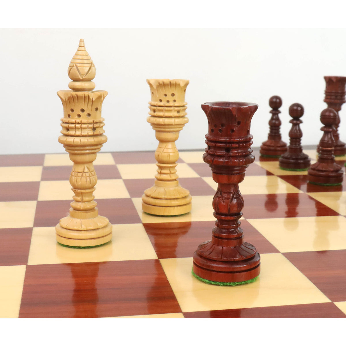 Elegant 4.7" Lotus Series King in Bud Rosewood and Queen in Boxwood on a wooden board.